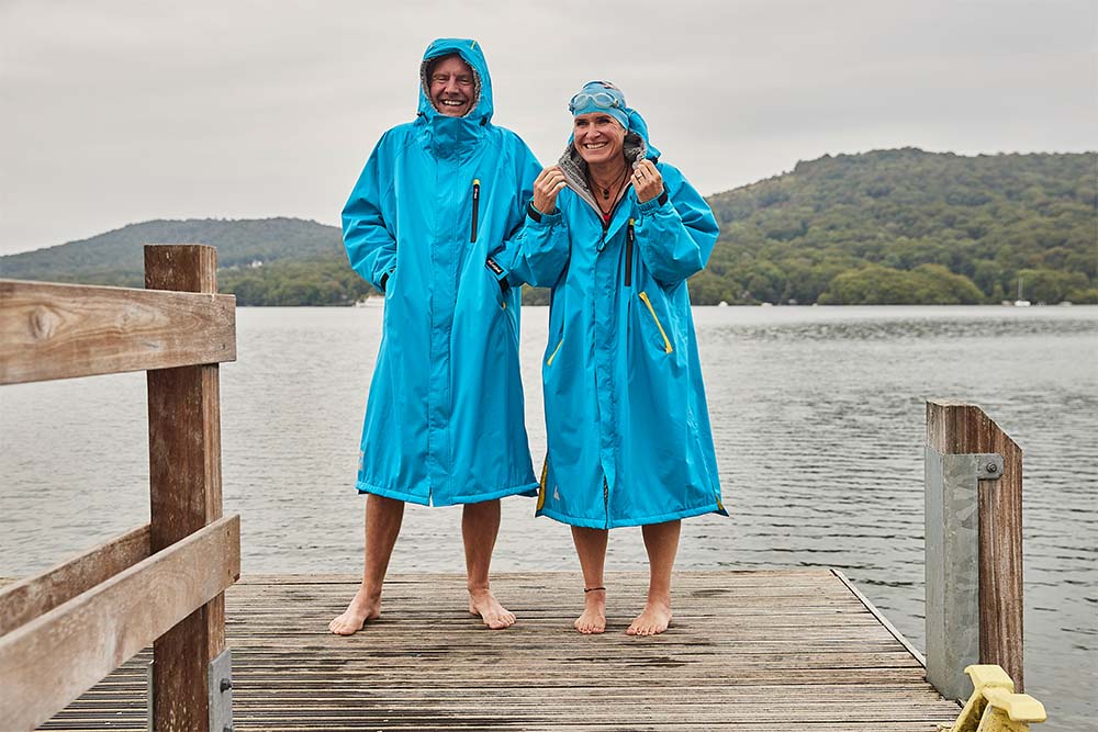 Two people wearing Red Original waterproof changing robes