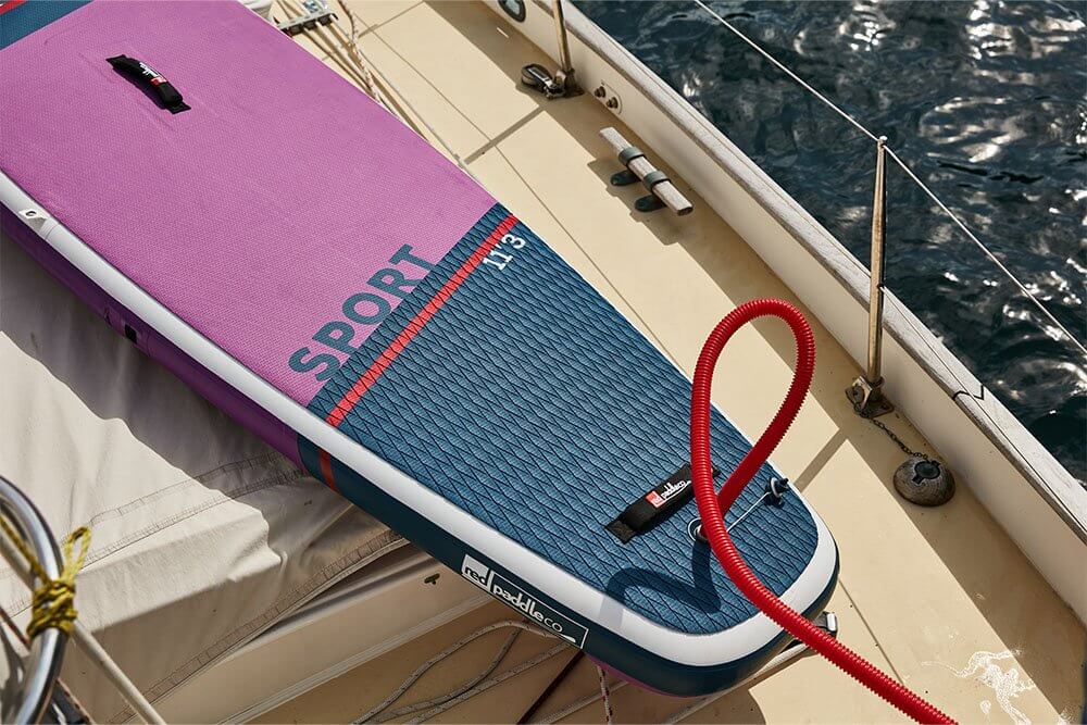 Red Original MSL inflatable SUP, using a coiled leash