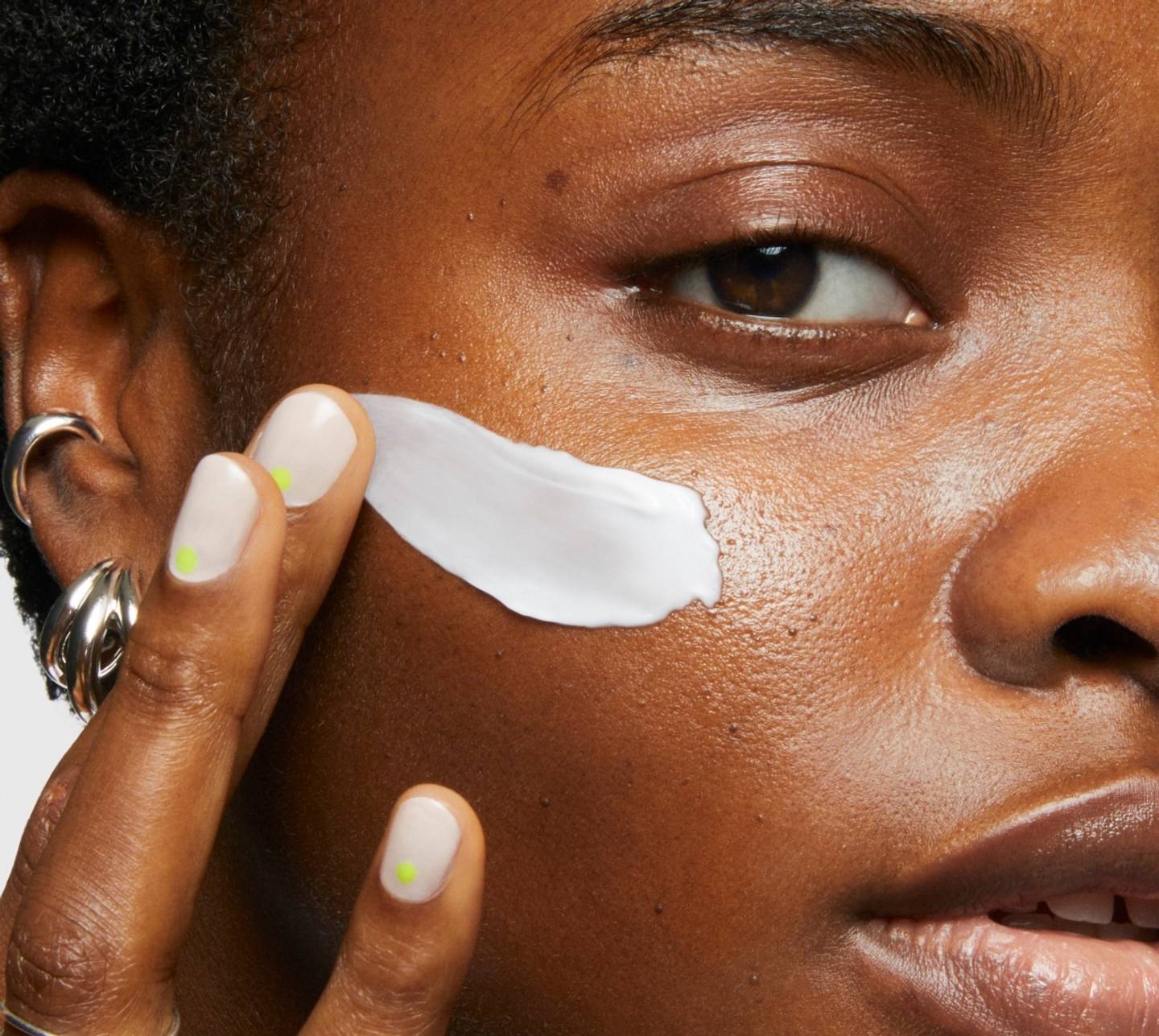 Model wears Milk Makeup Hydro Grip Primer on a white background.