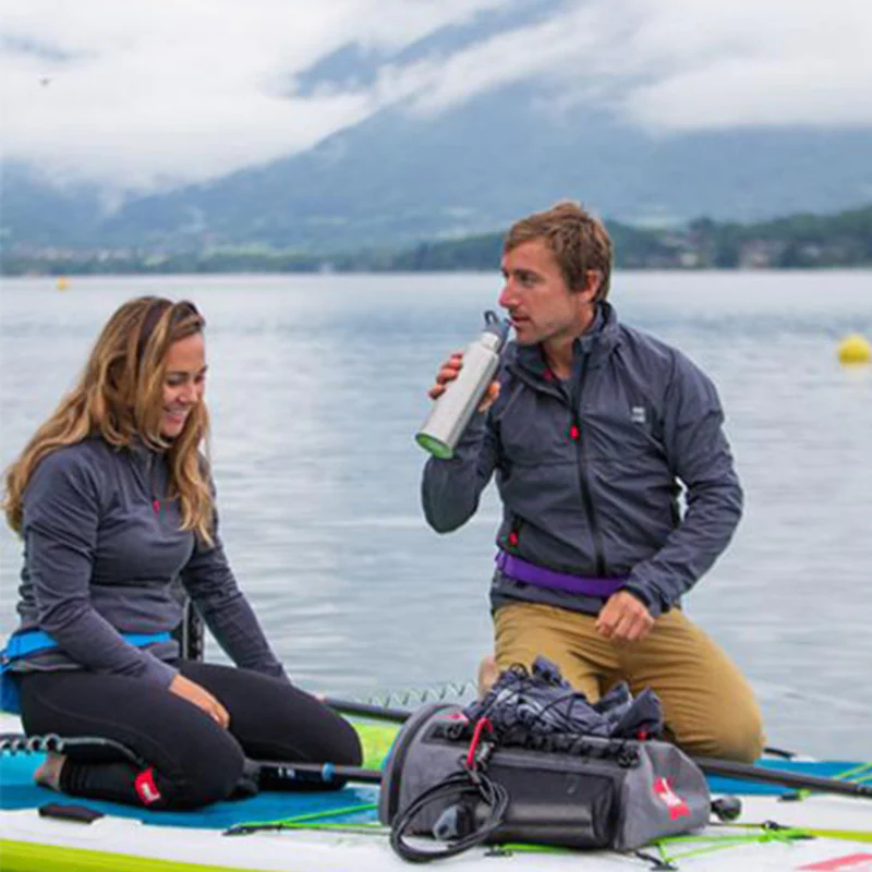 Man and woman sitting on paddle board with waterproof SUP deck bag

