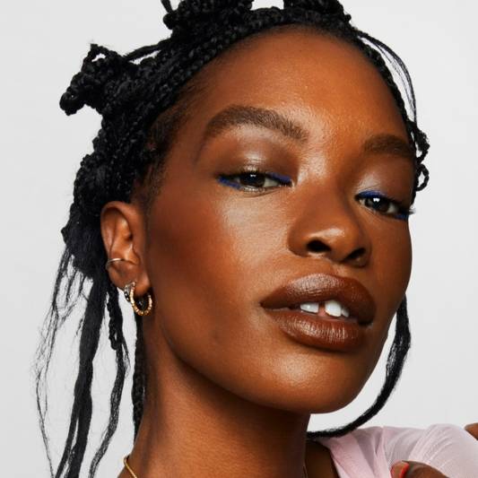 Model wears a full face of Milk Makeup products including Matte Bronzer against a white background