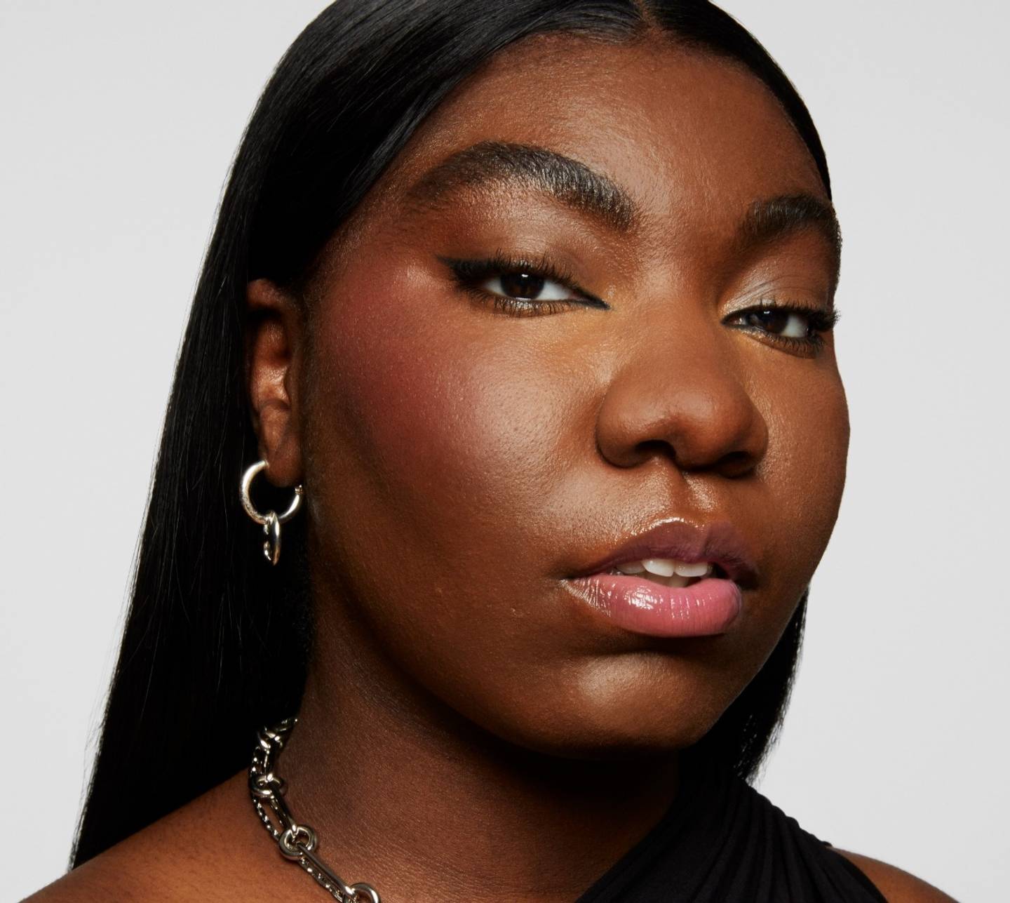 Naezrah wears a full face of Milk Makeup products including Pore Eclipse Matte Setting Spray against a gray background