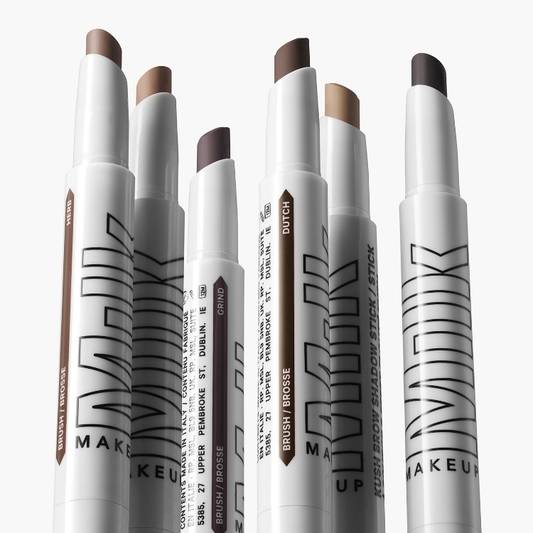 Multiple tubes of Milk Makeup KUSH Brow Shadow Stick on white background