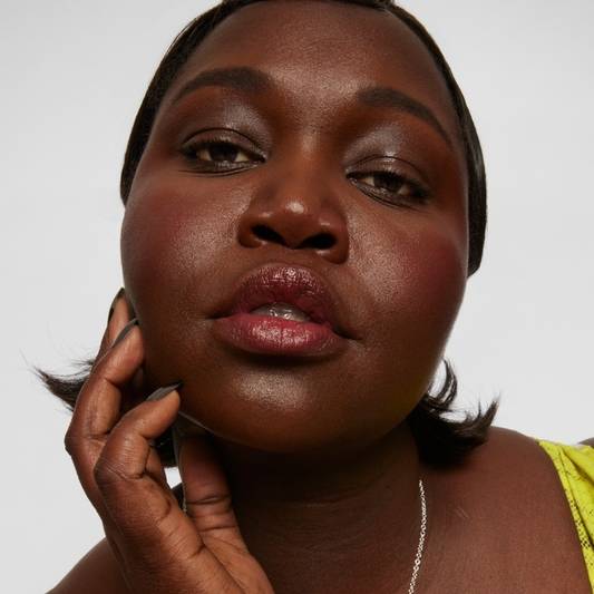 Model wears Milk Makeup KUSH Brow Shadow Stick on white background