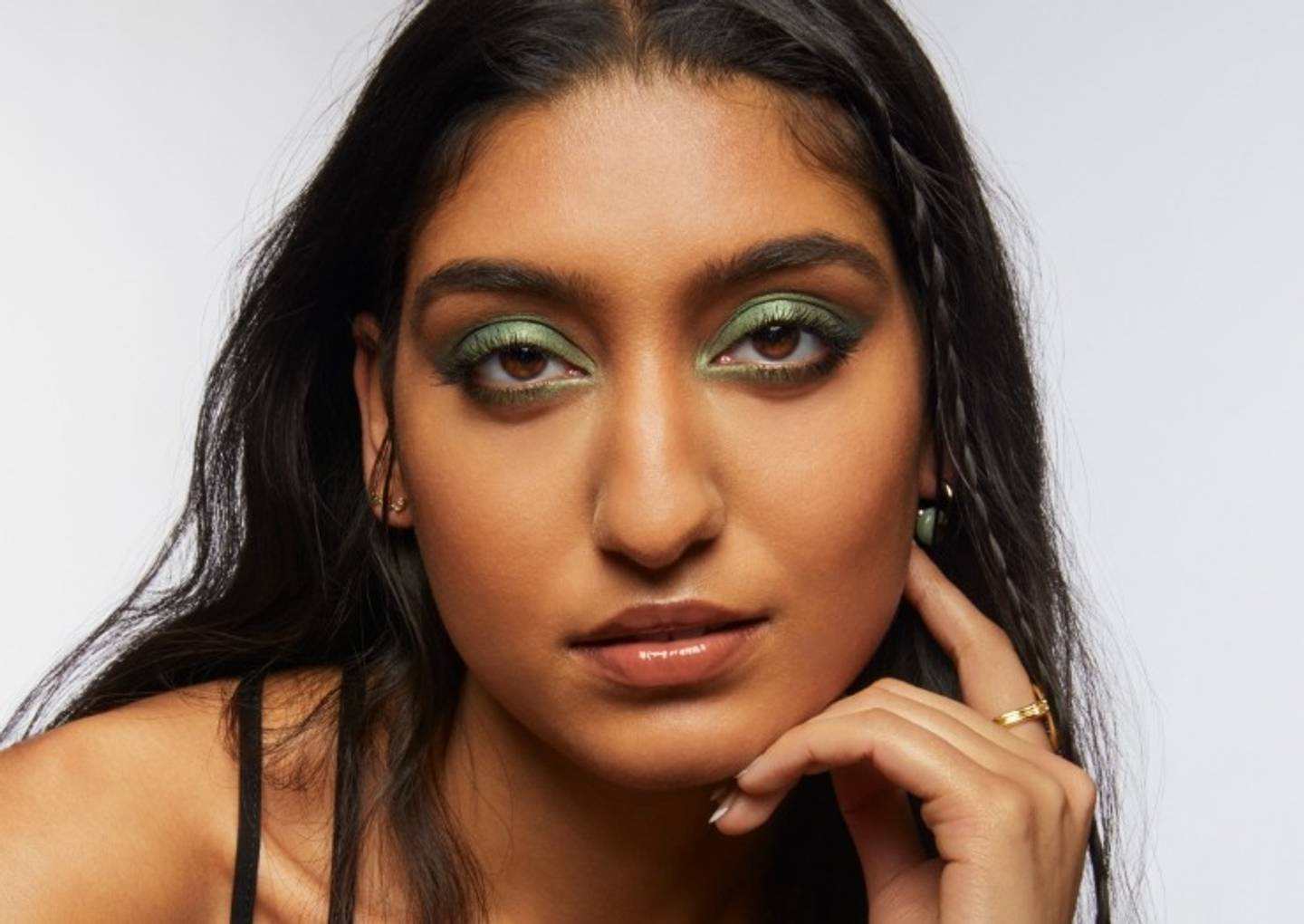 Portrait of Milk Makeup model Lizzy with smoky green eyeshadow on a white background