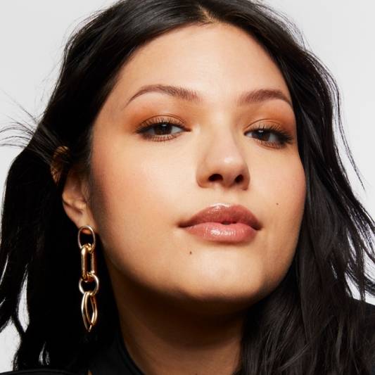 Portrait of Milk Makeup model Vanessa with a smoky warm neutral eye makeup on a white background