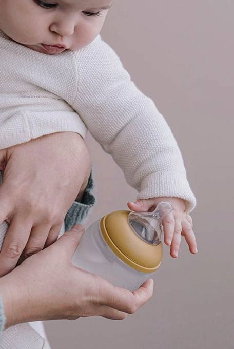 baby reaching for elhee baby bottle