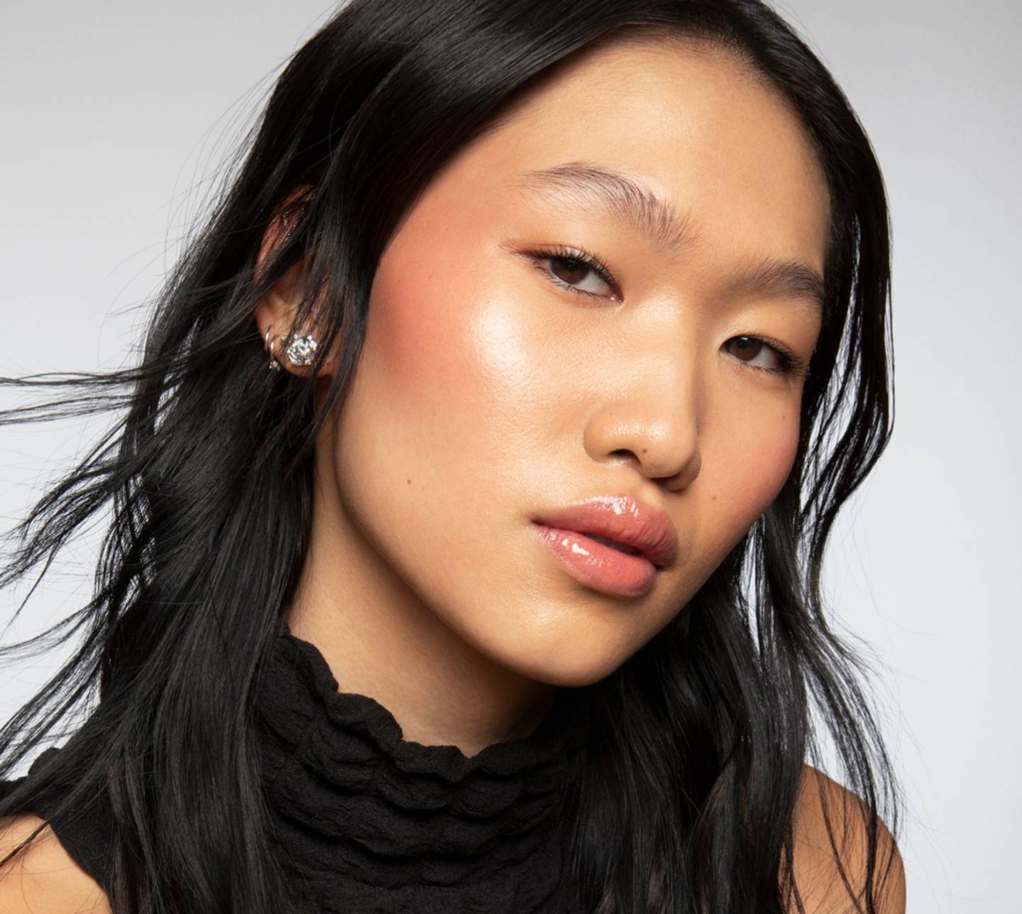 Model wears a full face of Milk Makeup products against a white background