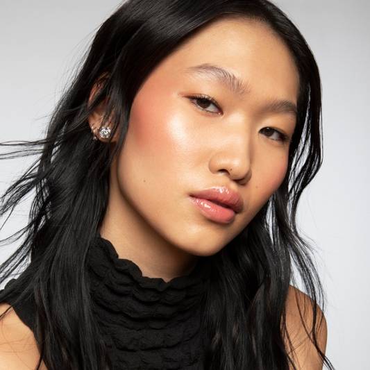 Model wears a full face of Milk Makeup products against a white background