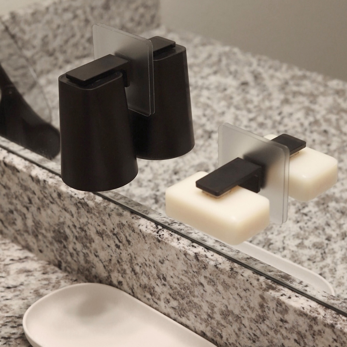 Traceless Adhesive Magnetic Cup Holder and Traceless Adhesive Magnetic Soap Holder by Yamazaki Home in black attached to a mirror.