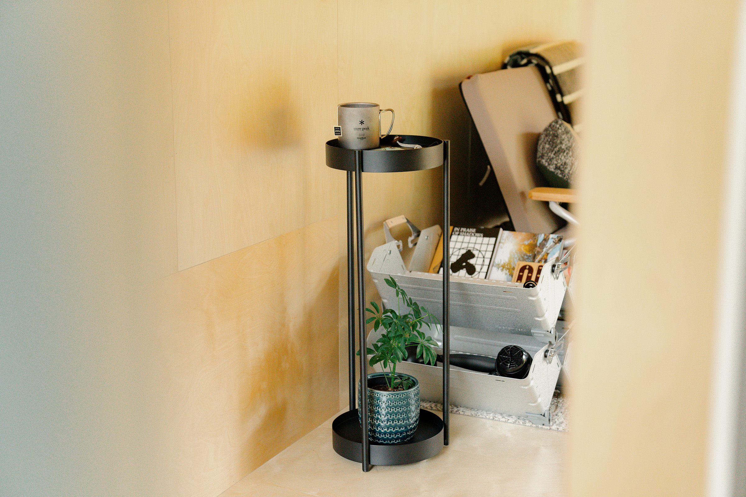 Yamazaki. Home Two-tier plant stand in black holding plants. 