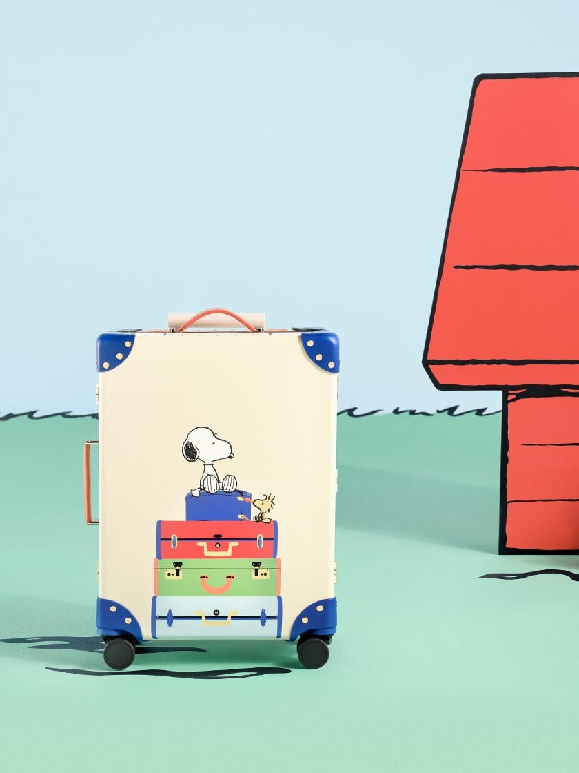 Globe-Trotter x PEANUTS Collaboration. Carry-On (Cabin) Suitcase With Four Wheels Featuring Snoopy and Woodstock in Ivory and Cobalt Blue.