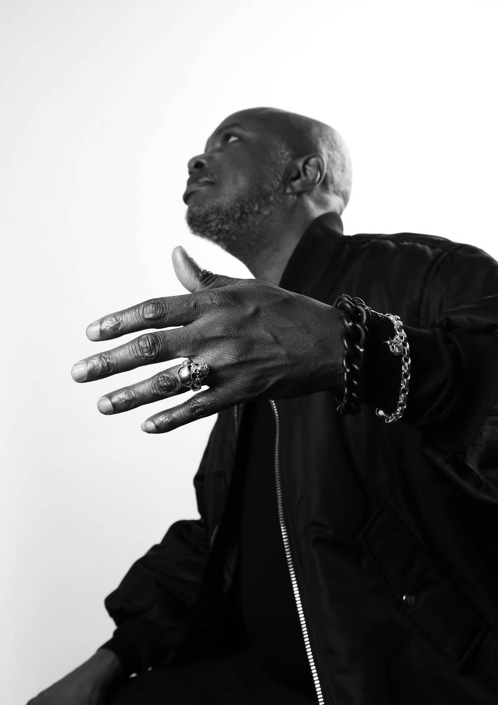 A man is wearing a silver full face skull ring.