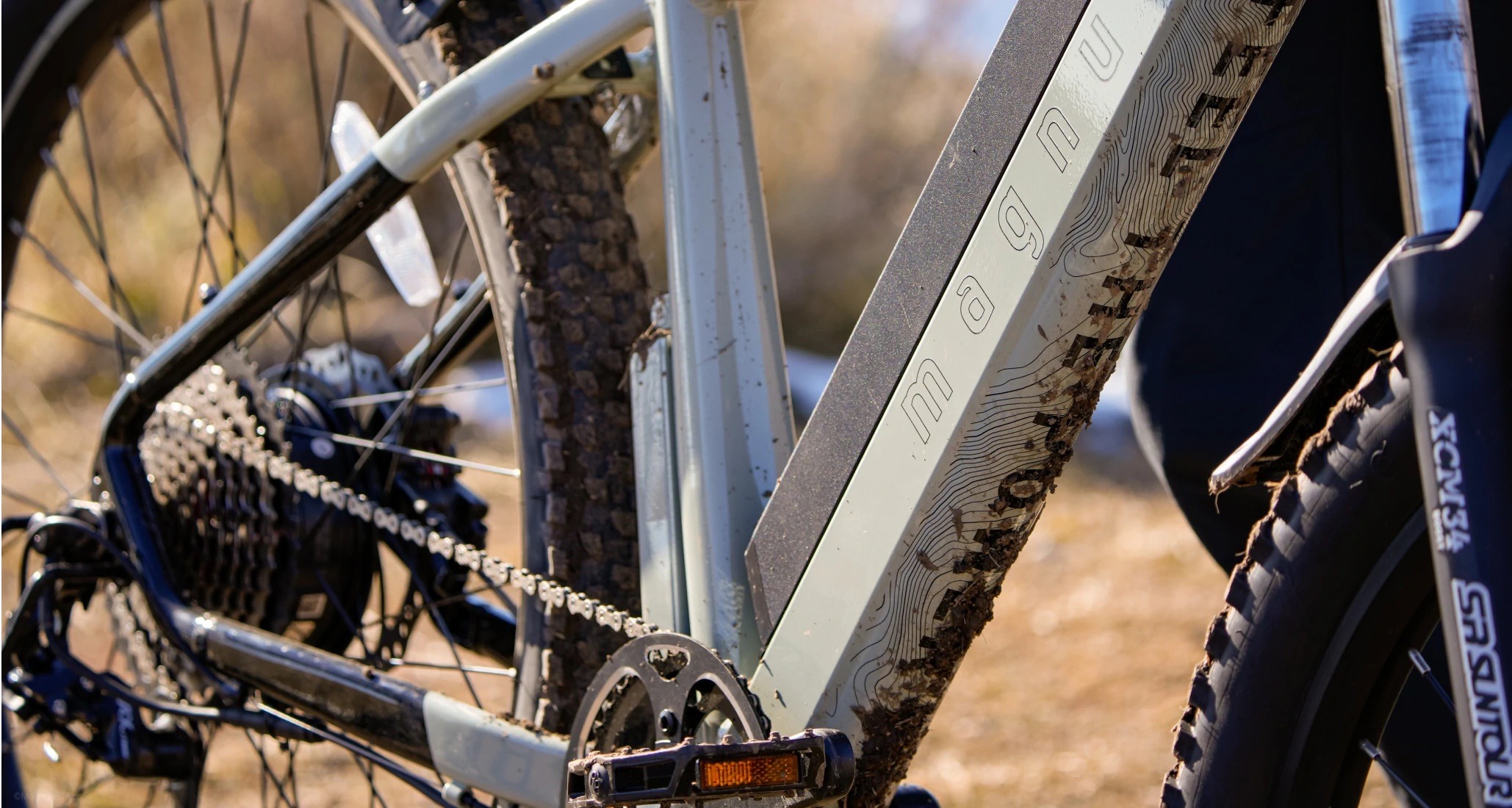Close-up of Magnum Peak T7 electric bike covered in dirt and mud