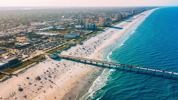 An aerial view of the beach, pier, and city in Jacksonville, FL