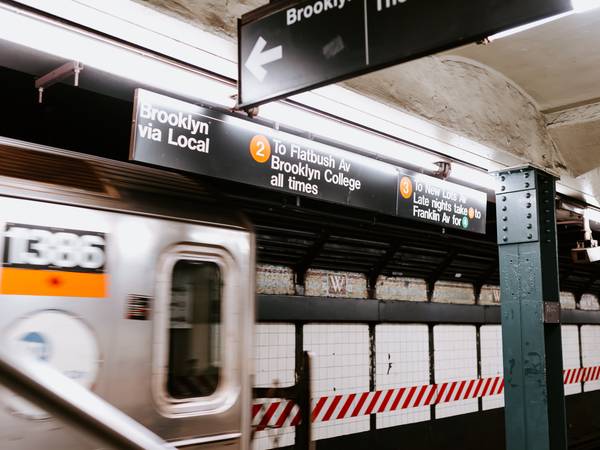 Interior of the New York City subway showing a train car moving out of the frame