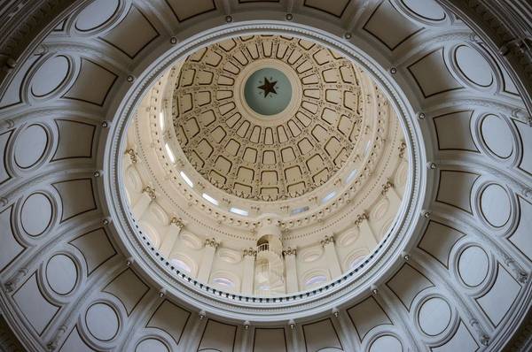 Interior shot looking up at the ceiling of the Texas State Capitol Building, which features the iconic lone star at the top of the dome.