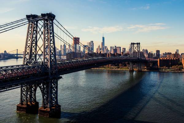 View of the Williamsburg Bridge crossing the East River into Manhattan near sunset