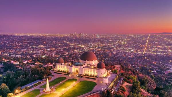 Purple and pink sunset over Los Angeles, with Griffith Observatory in the foreground and downtown in the distance
