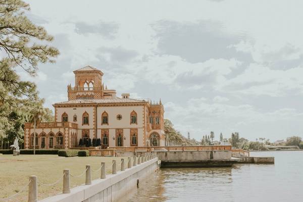 Stylized faded photograph of Sarasota's Ringling Museum on the waterfront with green grass and steps down to a dock