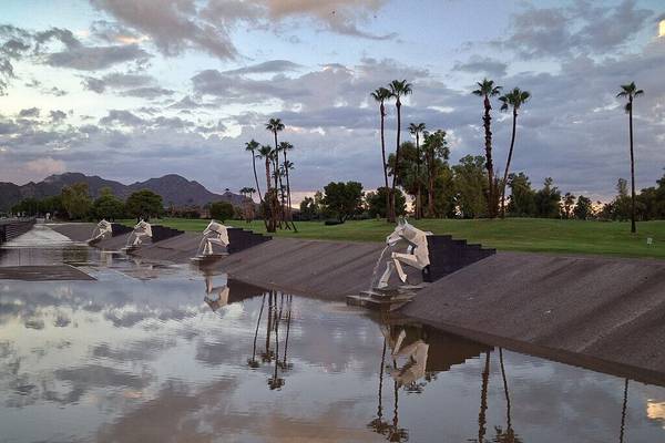 Water drains from metal sculptures along the Indian Bend Wash Greenbelt e-bike path in Scottsdale, Arizona after a summer monsoon thunderstorm