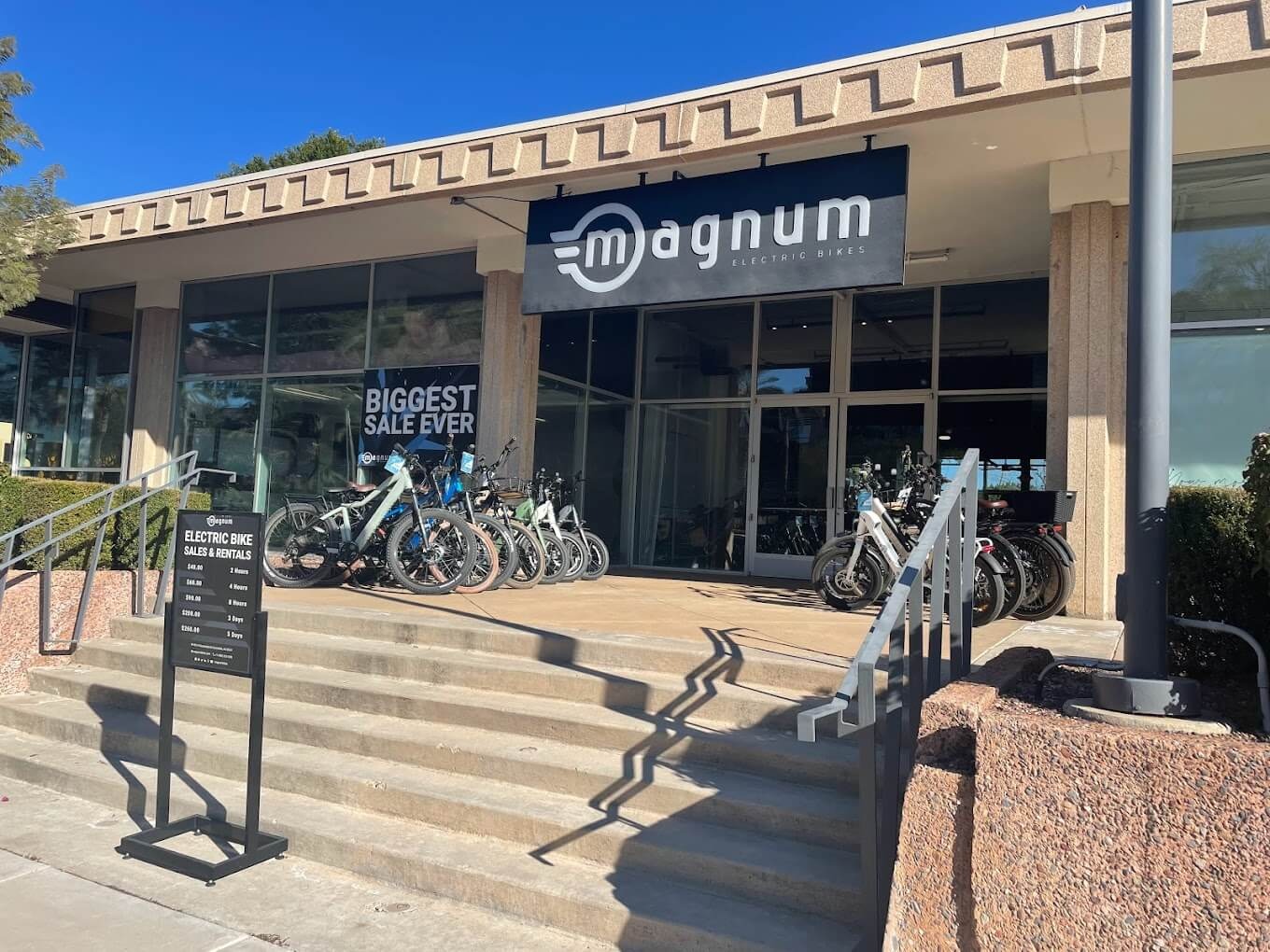 E-bikes on display outside the beige desert architecture of the Scottsdale Magnum Bikes store on a sunny day