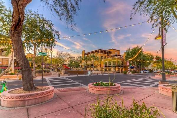 A pink-hued view of an intersection in the downtown area of Scottsdale, Arizona, with desert buildings and trees