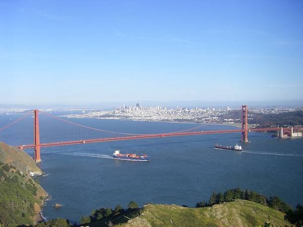 Blue skies and some haze over San Francisco Bay, looking from Marin Headlands past the Golden Gate Bridge to the city of San Francisco in the distance