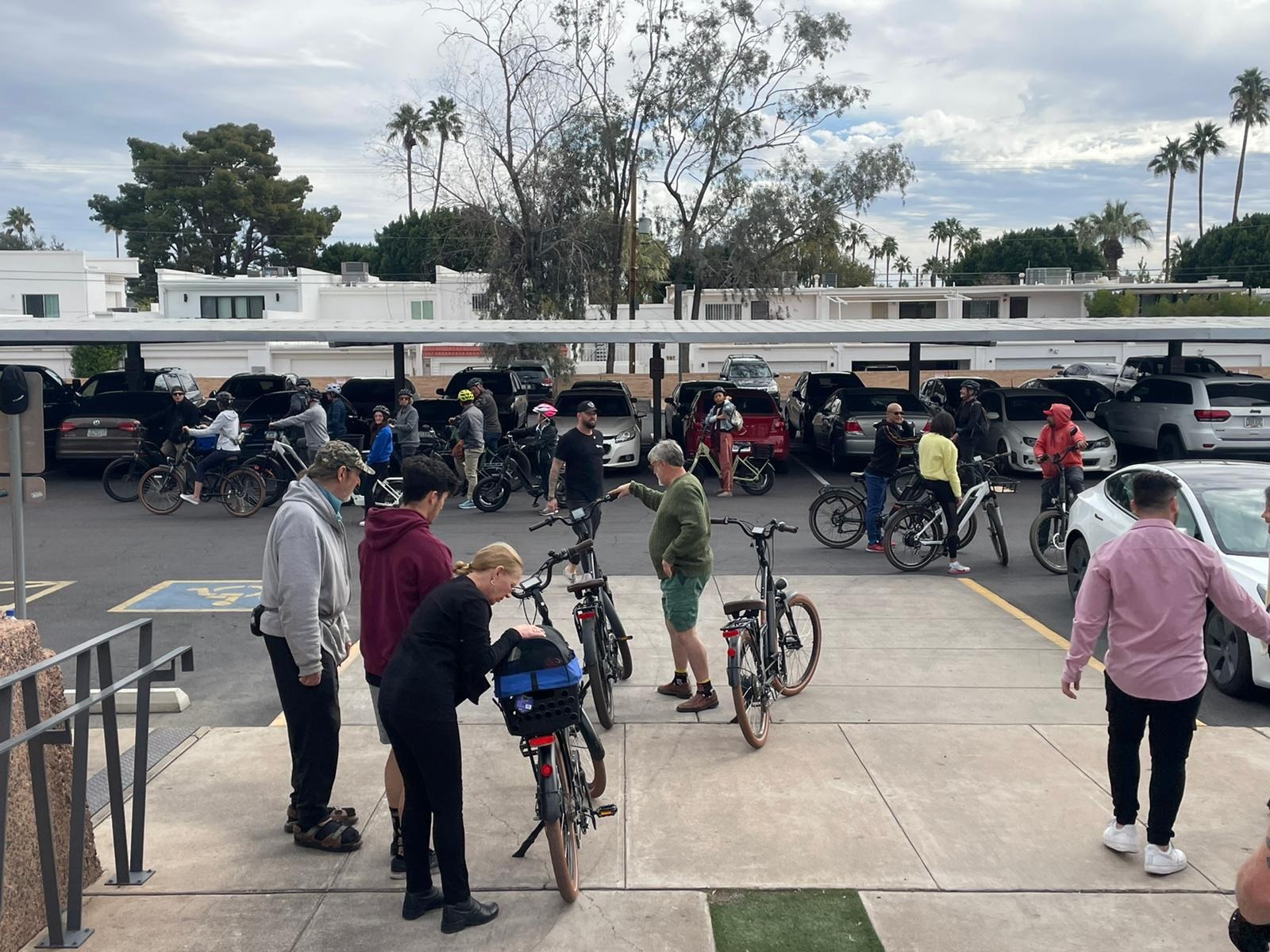 A group of people spread out in a parking lot, all with electric bikes ready for a group e-bike ride starting from the Magnum Bikes Scottsdale store during our Mental Health Awareness Event