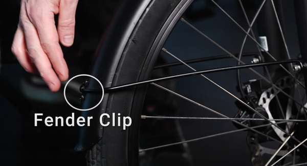 A hand points out the location of the fender clip, which sits on top of the fender and helps secure the fender holder to the fender