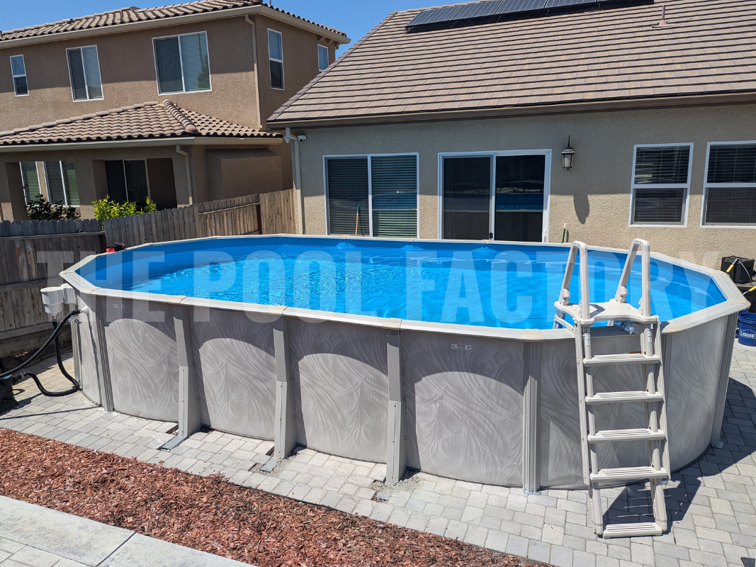 Above ground oval swimming pool with surrounding stone patio