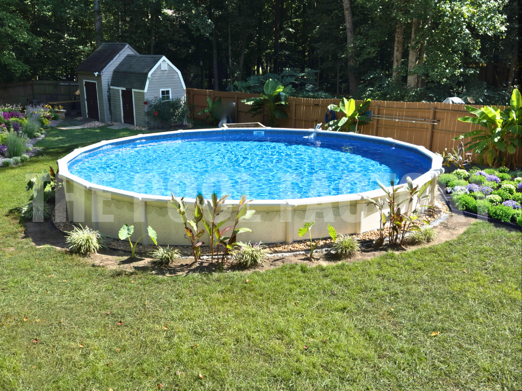 Round above ground swimming pool with decorative plants and a well-maintained flower garden