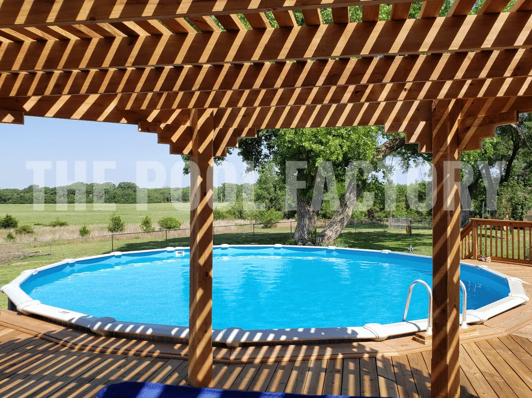 Sunny backyard featuring round pool with wooden deck and pergola