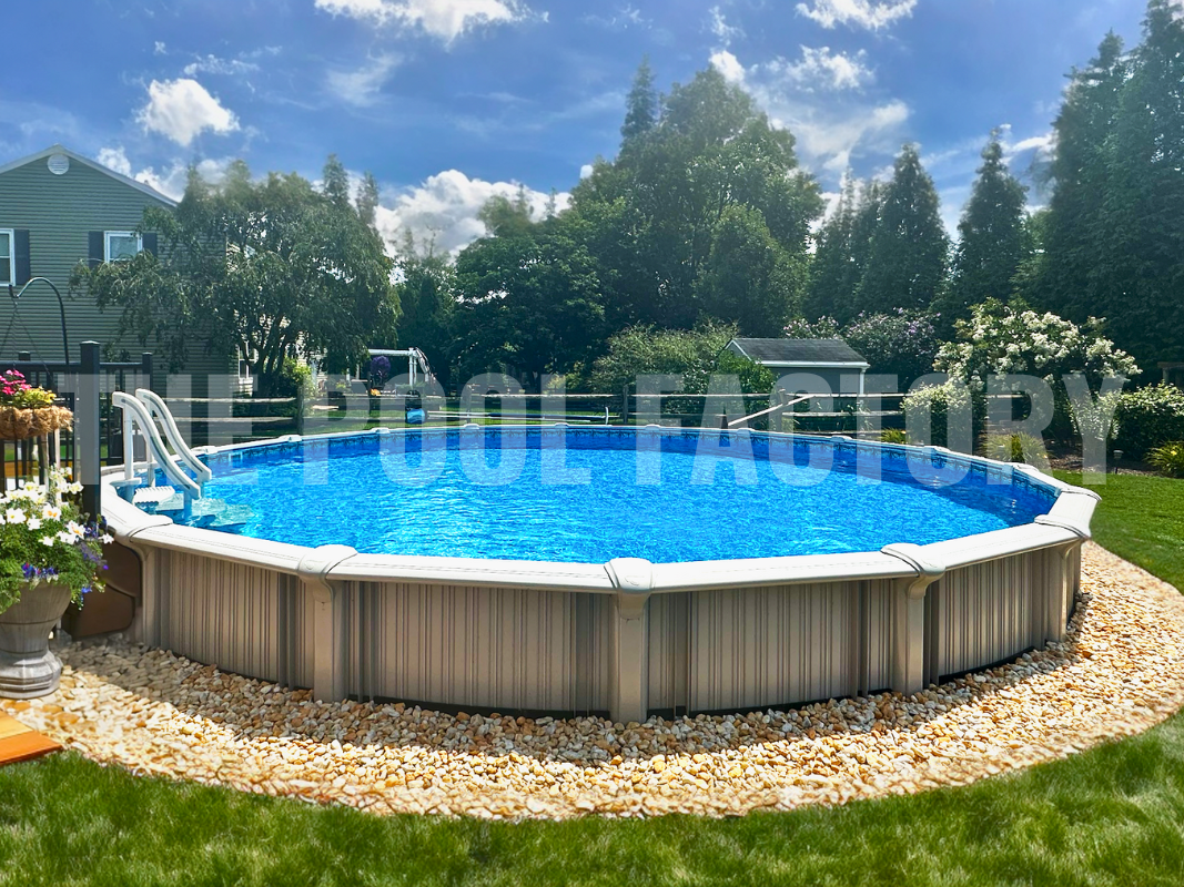 Backyard with round semi inground swimming pool, decorative rocks, and partial deck
