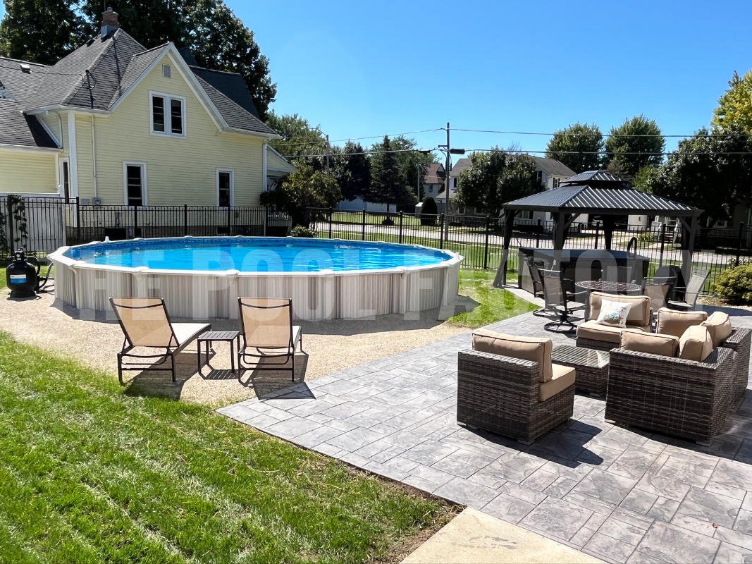 Round above ground swimming pool with decorative stonework, lounge chairs and gazebo