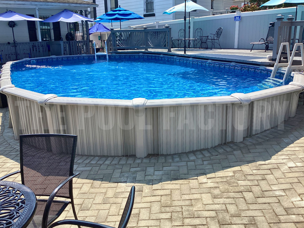 Oval semi-inground pool with partial deck and stone patio surrounding