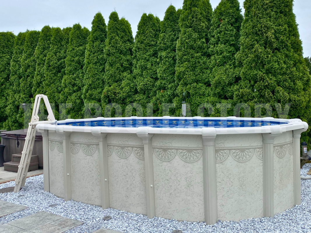 Oval above-ground swimming pool surrounded by green hedges with decorative stone pathway