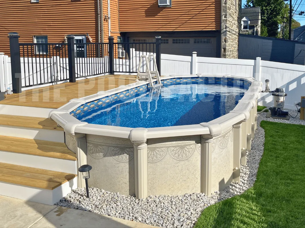 Oval pool with partial deck for seating and concrete patio