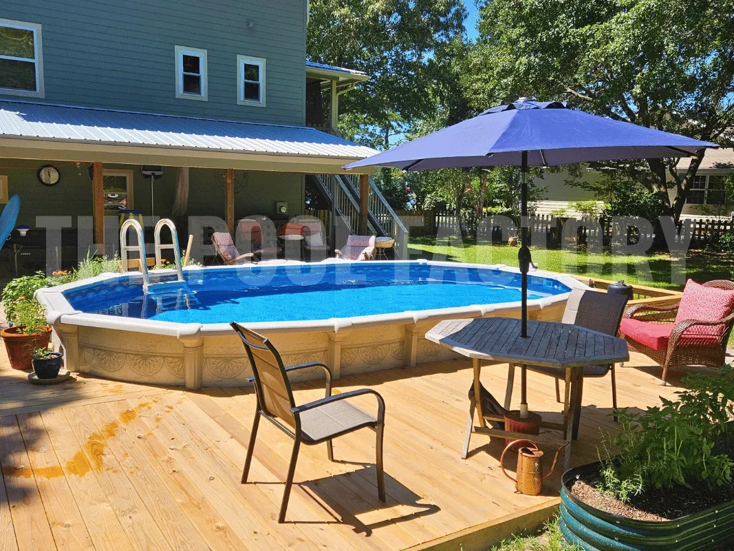 Oval semi-inground pool with partial deck, grass, and umbrella-covered seating