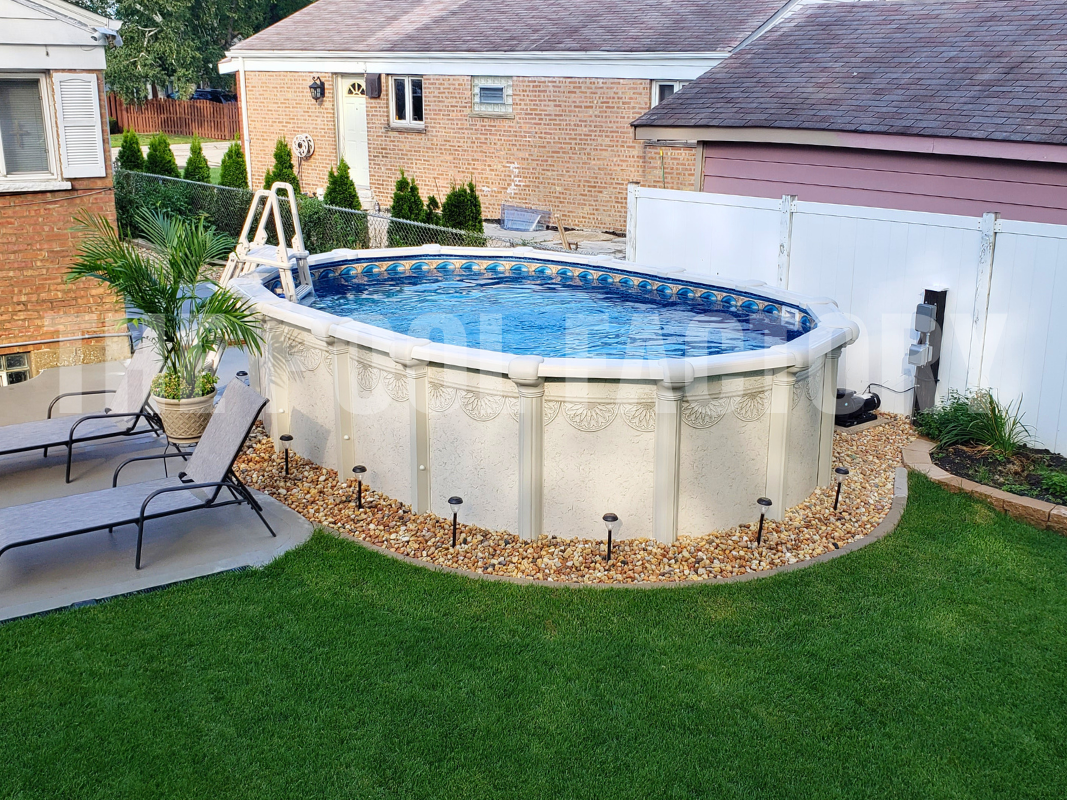 Oval above ground swimming pool with turf and comfortable lounge chairs