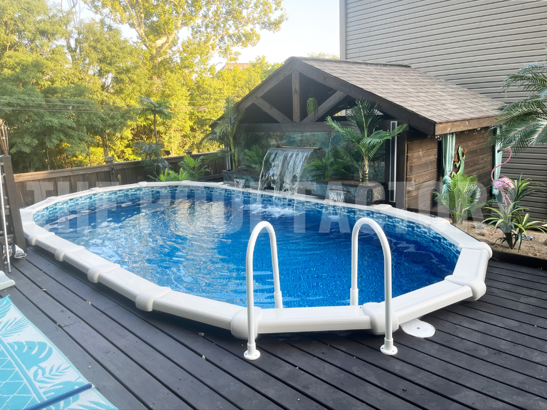 Oval swimming pool with a deck and garden plants in a cozy backyard