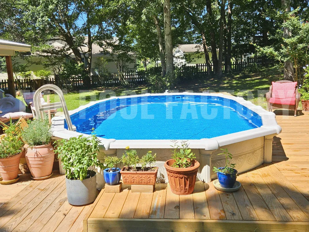 Oval semi-inground pool with deck, lounge chairs, and garden plants along the edge