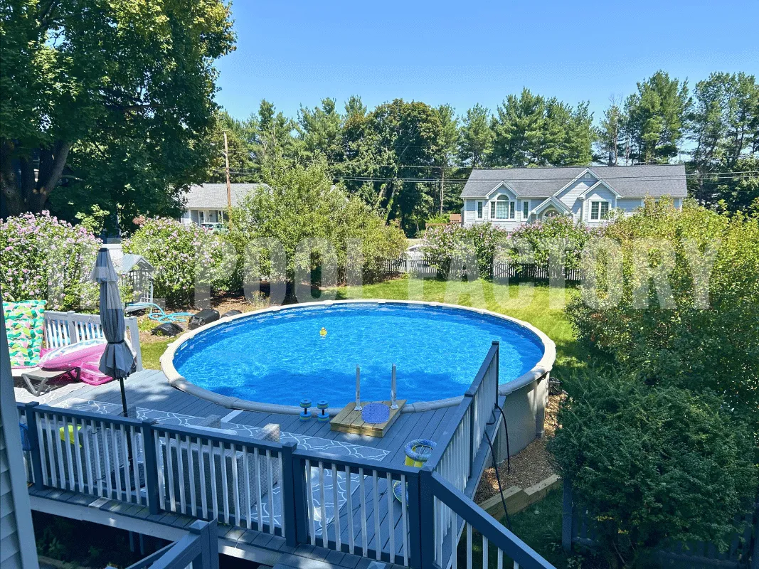 Round pool with partial wood deck, vibrant landscaping, and mulch border around exterior