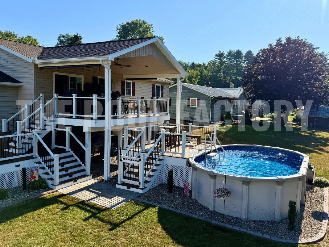 Above ground pool with partial deck, decorative border, and lush backyard grass