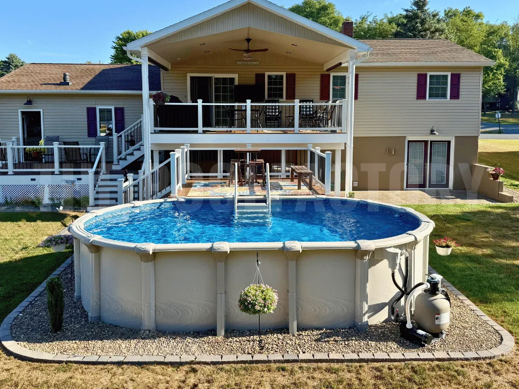 Oval above ground pool with composite partial deck, decorative gravel border, and green lawn