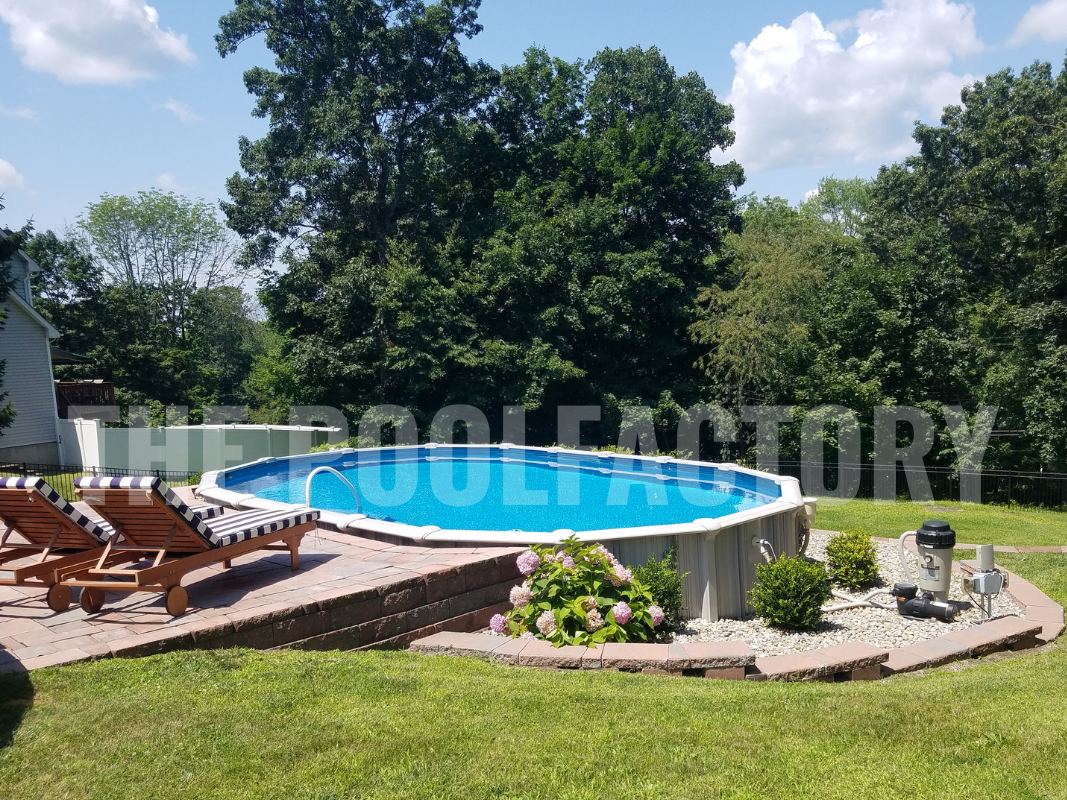 Semi-inground oval swimming pool with sunny patio and forest landscape