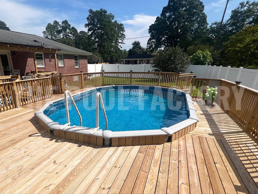 Above ground swimming pool with full wooden deck on a sunny clear day