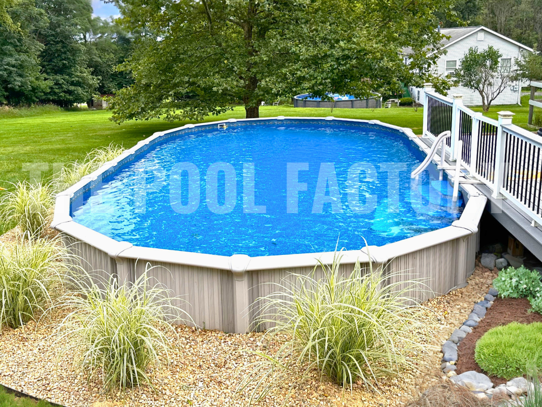 Above ground oval swimming pool with, shrubs, and deck