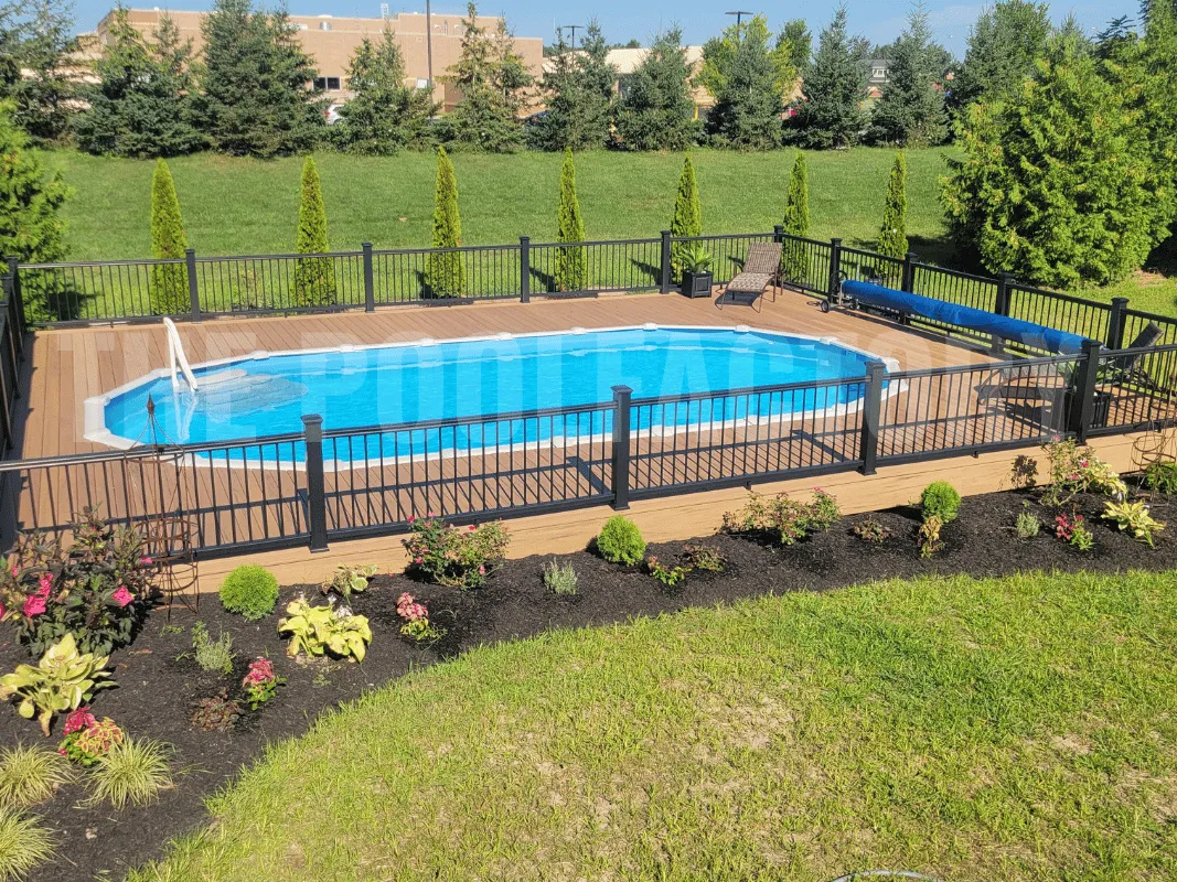Oval semi-inground pool with full Trex decking and decorative plants