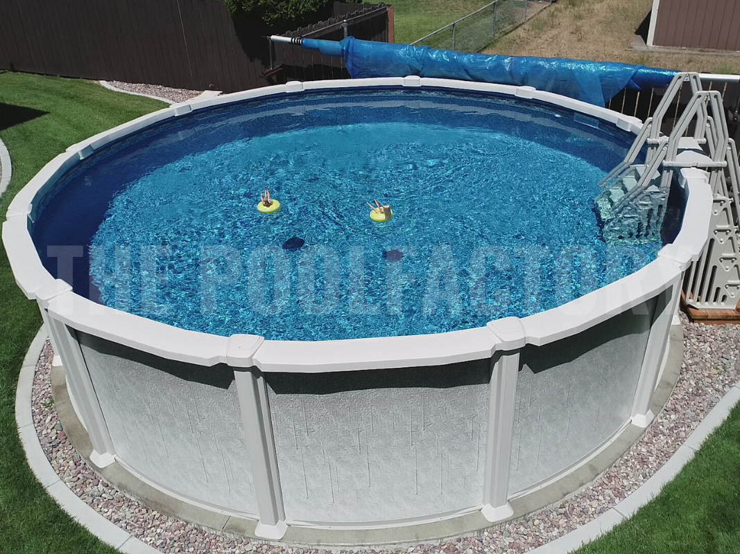 Round above ground saltwater swimming pool with stone pavers and neatly cut grass
